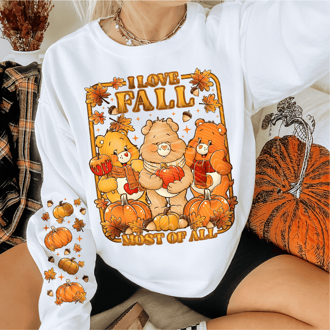 Person wearing a white sweatshirt with 'I love fall most of all' graphic design. cozy-fall-bear-sweatshirt