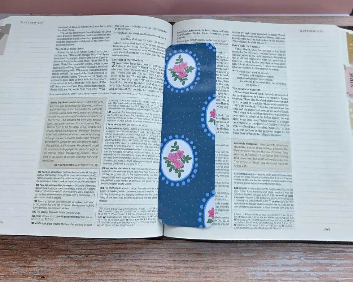 Open book with decorative floral page markers on a wooden surface.coquette-floral-bookmarks