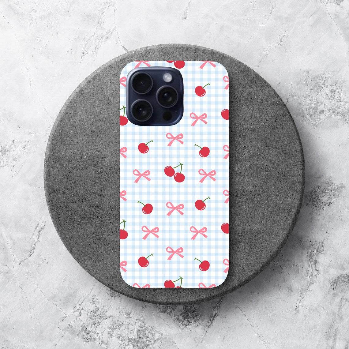 Phone case with cherry and bow pattern on a white background.coquette-phone-case