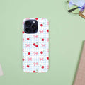 Phone case with cherry and bow pattern on a light green background.coquette-phone-case