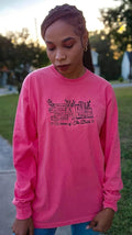 A woman wearing a pink long-sleeved t-shirt with embroidered text that reads 'Women of the Bible' and includes images of various women mentioned in the Bible.women-of-the-bible-shirt