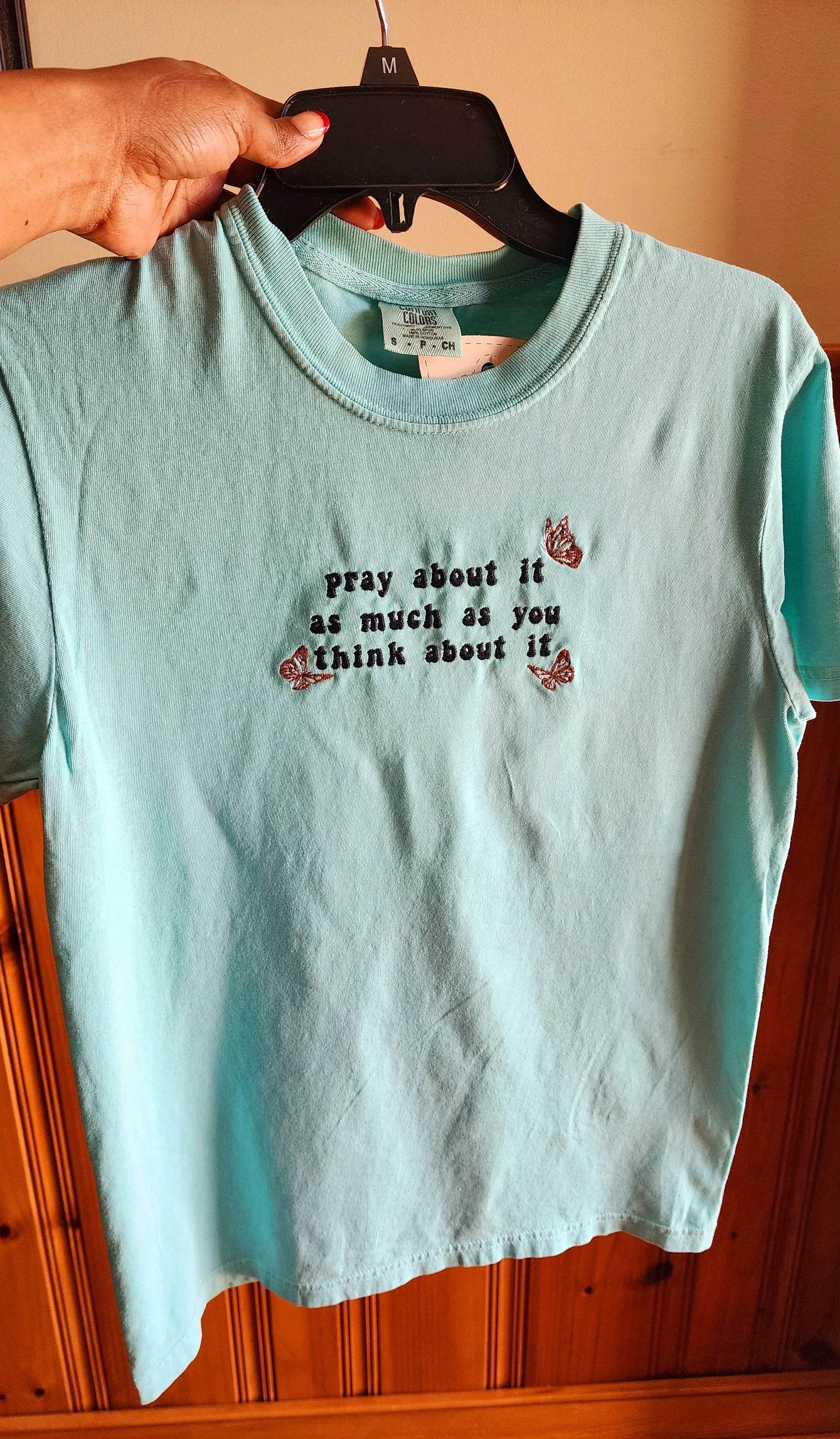 A blue t-shirt with the text 'pray about it as much as you think about it' printed on the front. pray-t-shirt