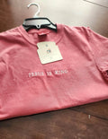 A pink short sleeve shirt with the phrase 'Jesus Is King' embroidered in a darker color across the front.jesus-is-king-shirt