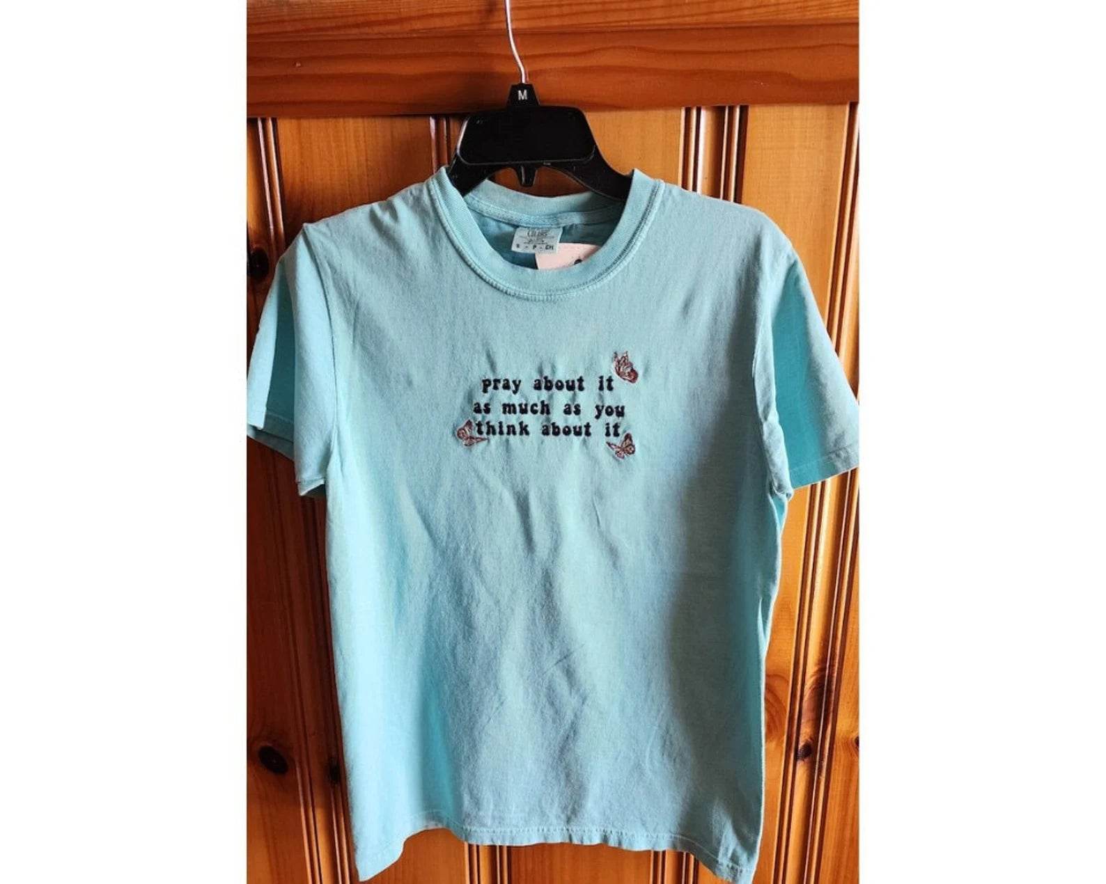 A blue t-shirt with the text 'pray about it as much as you think about it' printed on the front. pray-t-shirt