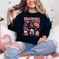A woman sitting and smiling, wearing a black sweatshirt with a Valentine's Day-themed graphic, surrounded by red heart-shaped balloons.valentines-sweatshirt-for-women