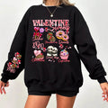 A woman  wearing a black sweatshirt with a Valentine's Day-themed graphic, surrounded by red heart-shaped balloons.valentines-sweatshirt-for-women