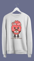 A white crewneck sweatshirt with a graphic of an anatomical heart holding a coffee cup and the phrase 'I live on caffeine.'.