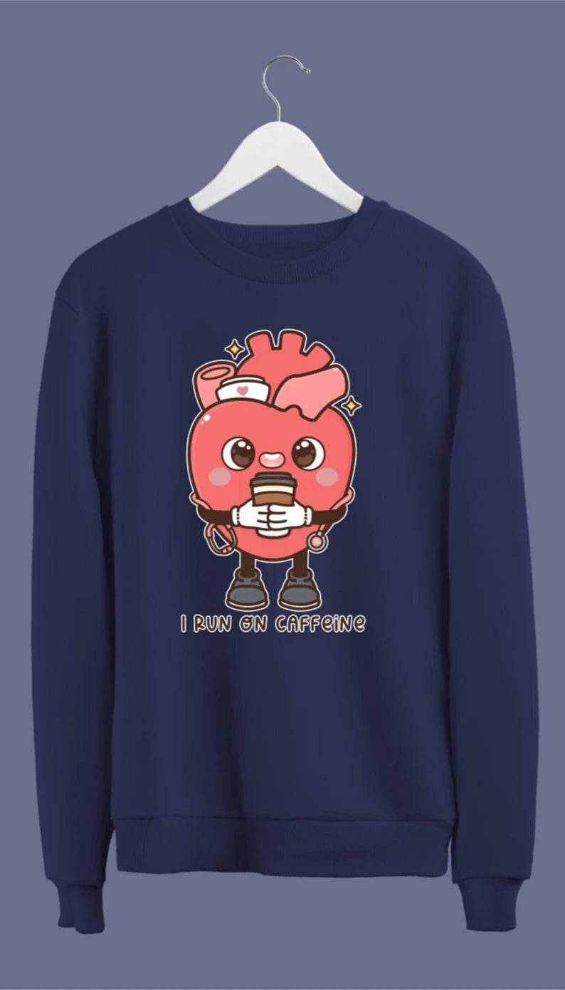 A navy blue crewneck sweatshirt with a graphic of an anatomical heart holding a coffee cup and the phrase 'I live on caffeine.'.