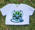White  Heartbeat Stethoscope T-Shirt, lying on a grassy surface.