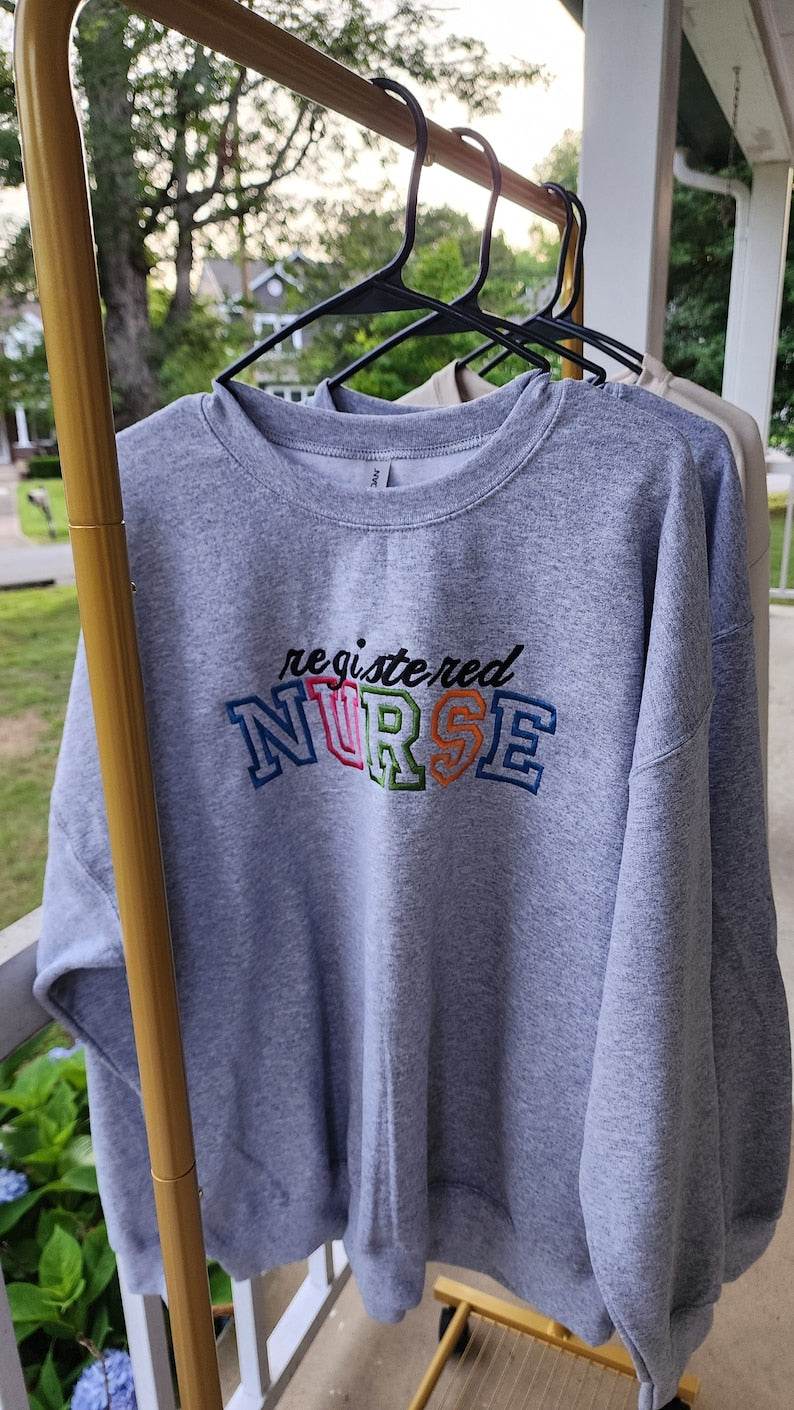 A collection of embroidered crewneck sweatshirts with the word 'NURSE' and 'registered NURSE' embroidered 