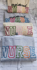 A collection of embroidered crewneck sweatshirts with the word 'NURSE' and 'registered NURSE' embroidered