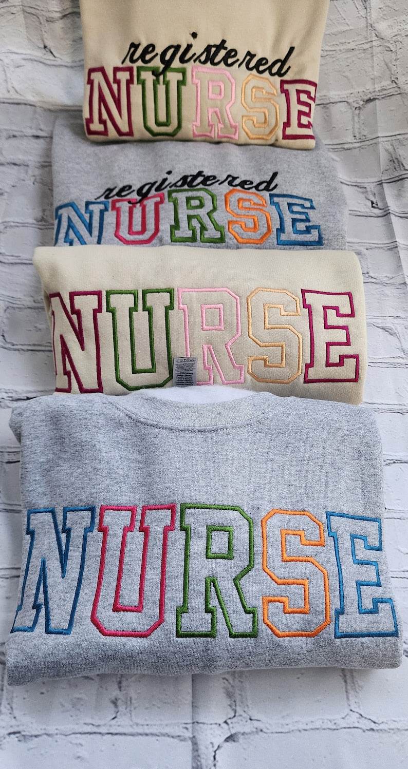 A collection of embroidered crewneck sweatshirts with the word 'NURSE' and 'registered NURSE' embroidered