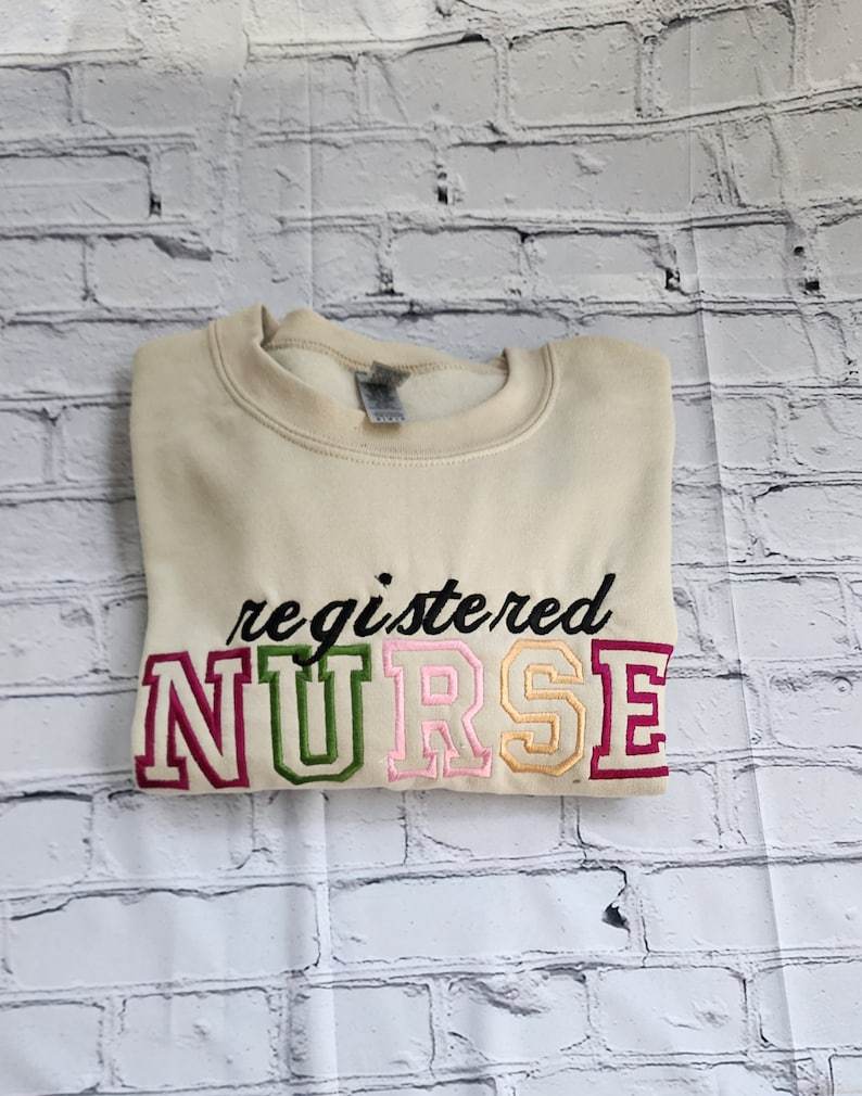 A collection of embroidered crewneck sweatshirts with the word 'NURSE' and 'registered NURSE' embroidered