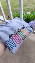 A collection of embroidered crewneck sweatshirts with the word 'NURSE' and 'registered NURSE' embroidered