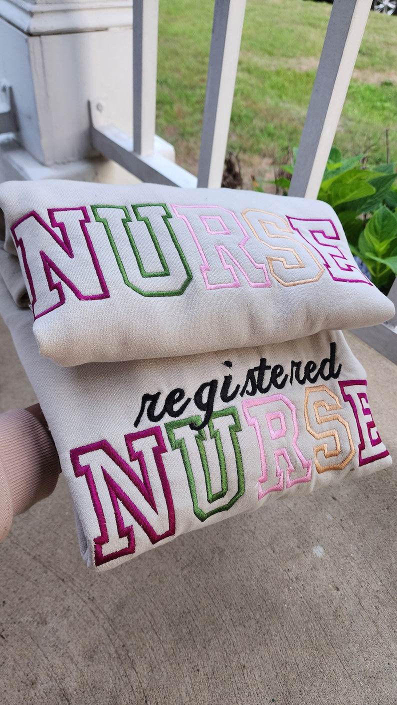 A collection of embroidered crewneck sweatshirts with the word 'NURSE' and 'registered NURSE' embroidered 
